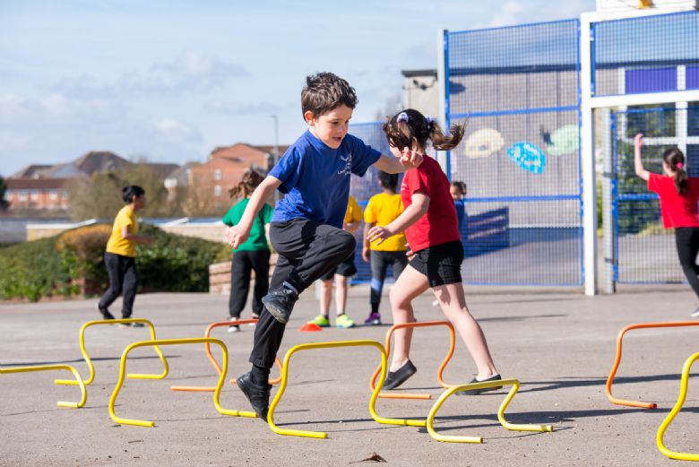  children play with sports equipment in the playground