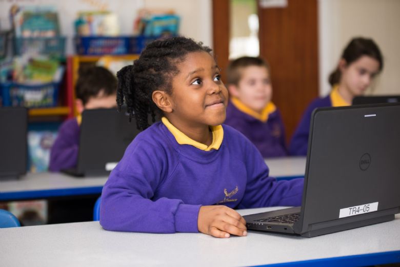 pupil works on a laptop computer in a classroom